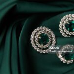 Emerald ring and pair of diamond earrings in gold, wedding jewelry with luxury gift box , close-up. Selective focus